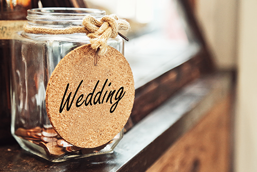 jar filled with coins and wedding sign on front