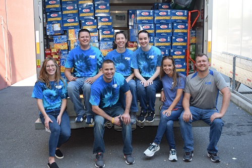 bank employees pictured with stacks of food to be donated