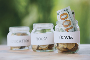 Image of a jar labeled "travel" filled with money.