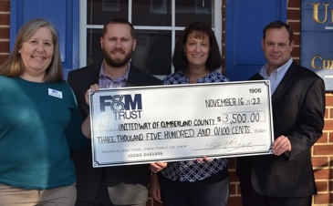 Two F&M Trust employees presenting large check to two United Way of Carlisle and Cumberland County employees.