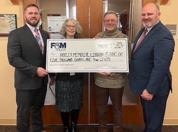 Two F&M Trust employees presenting large check to two Bosler Memorial Library employees.