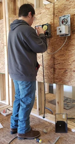 A student at a career and tech school is practicing his electrical skills