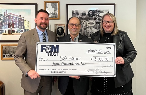 F&M Trust representatives present a large check to Safe Harbour