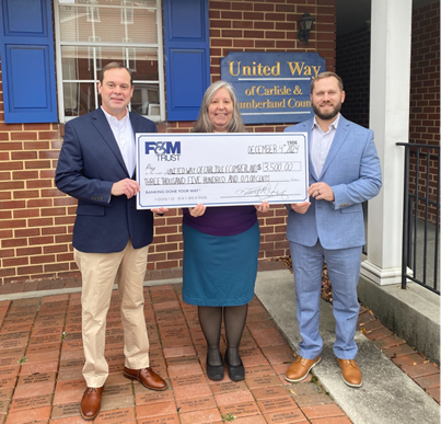 The United Way of Carlisle & Cumberland County Executive Director Cate Mellen accepts a check for $3,500 from F&M Trust Senior Relationship Manager Dave Zimmerman and Wealth Advisor Adam Hollinger.